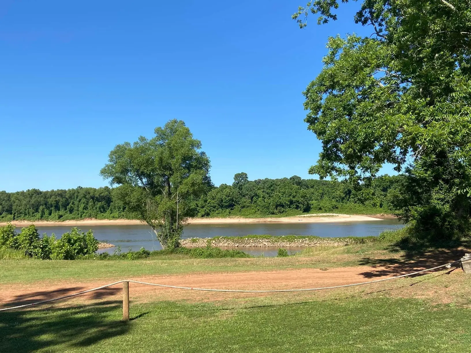 Grassy riverside area overlooking a Red River sandbar at River Island RV Park